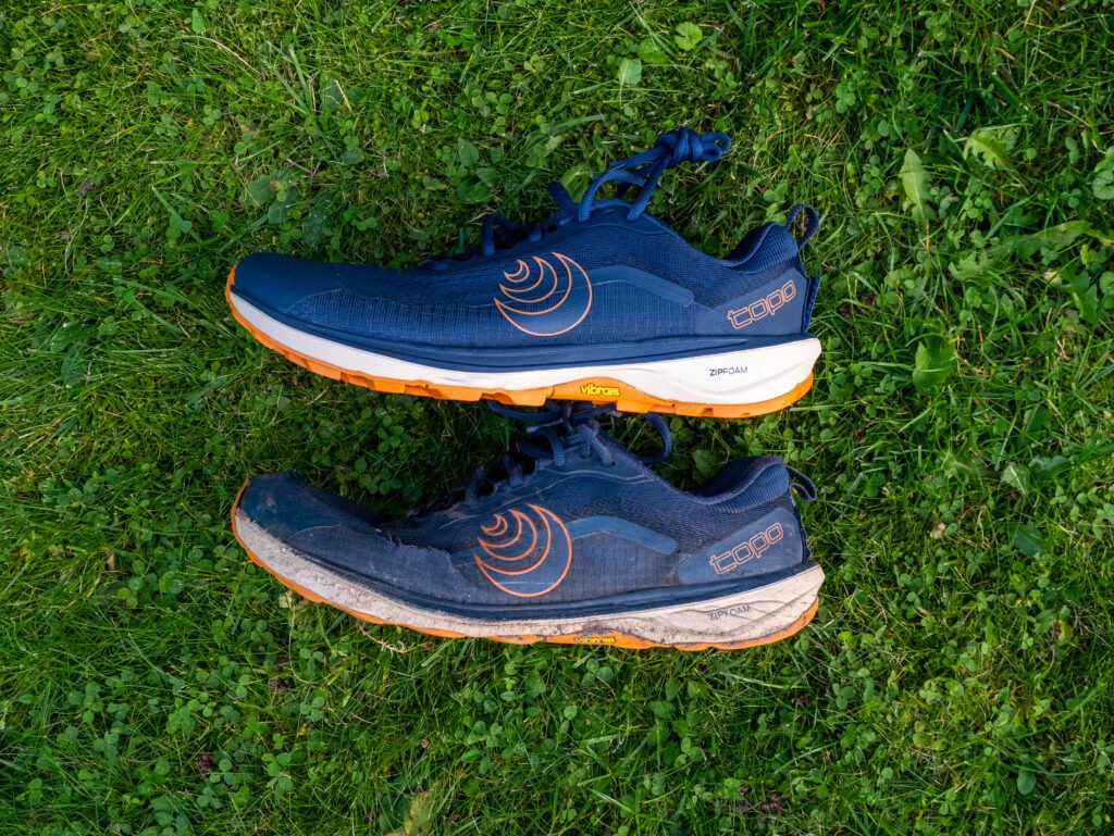 Topo Athletic Terraventure 5 im Vergleich von der Logoseite: neuer Schuh oben, getragener Schuh nach 730 km unten